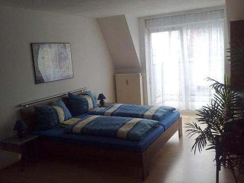 Bett in einem Zimmer mit einem großen Fenster in der Unterkunft Apartment Berliner Strasse in Leipzig