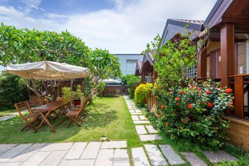 a backyard with a table and chairs and flowers at Liuqiu Star in Xiaoliuqiu