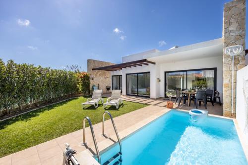 a backyard with a swimming pool and a house at Villa Front Loop in Sagres