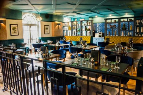 a restaurant with tables and chairs in a room at The Regency Hotel in Solihull