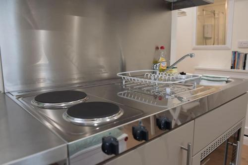 a kitchen with a stainless steel stove top oven at Self-contained annex with private entrance, double bed, kitchen, bathroom, free car park - Near Cambridge, Duxford Air Museum and Addenbrooke's Hospital in Cambridge