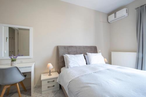 a bedroom with a white bed with a desk and a chair at Nafplio view in Nafplio