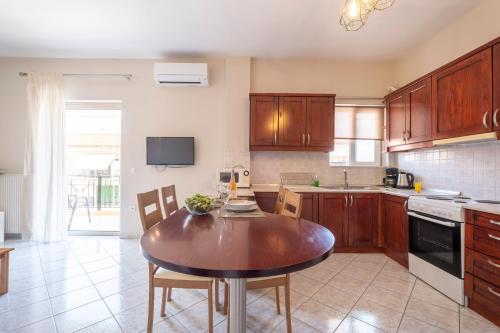 a kitchen with wooden cabinets and a wooden table at Nafplio view in Nafplio