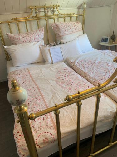 a large bed with a gold frame and pillows at Casa Wellness am Wald 140 qm Bed & Breakfast & Wellness in Mörlenbach