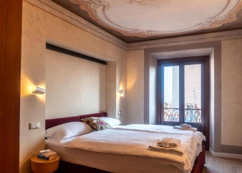 a bedroom with a large bed and a window at Leoni 7 in Menaggio