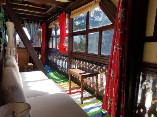a room with several beds and windows with red curtains at Mazot d'antan in Saint-Sixt