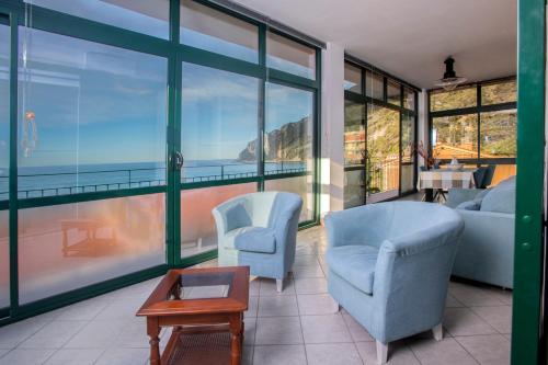 sala de estar con 2 sillas y sofá en 162 - La Veranda Sull'Acqua, Fronte e Vista Mare Riva Trigoso, POSTO AUTO PRIVATO en Sestri Levante