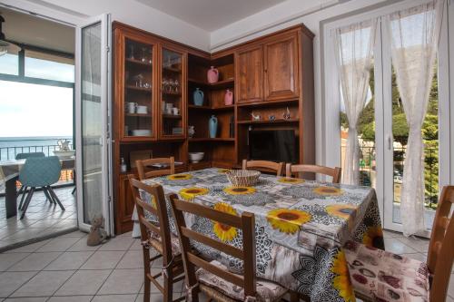 a dining room with a table with sunflowers on it at 162 - La Veranda Sull'Acqua, Fronte e Vista Mare Riva Trigoso, POSTO AUTO PRIVATO in Sestri Levante