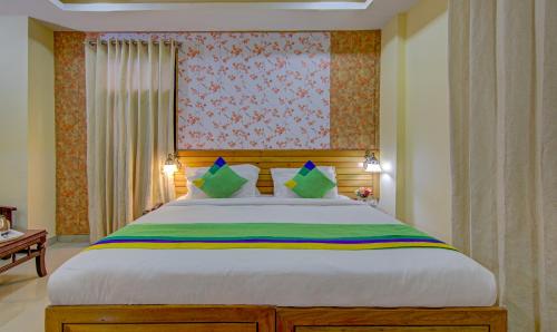 a bedroom with a large bed with green pillows at Treebo Roshan House with Valley View in McLeod Ganj