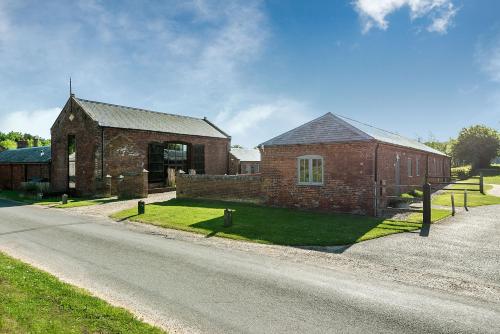 a brick building on the side of a road at Coot in Fakenham