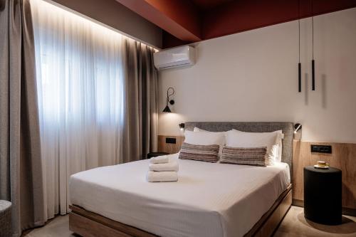 - une chambre avec un grand lit blanc et des serviettes dans l'établissement Vinnies Homes, à Héraklion