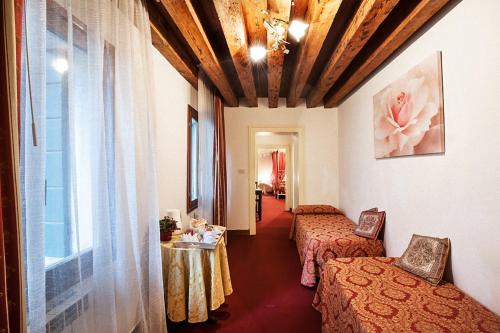 Cette chambre comprend 2 lits et une table. dans l'établissement Maison San Marco, à Venise