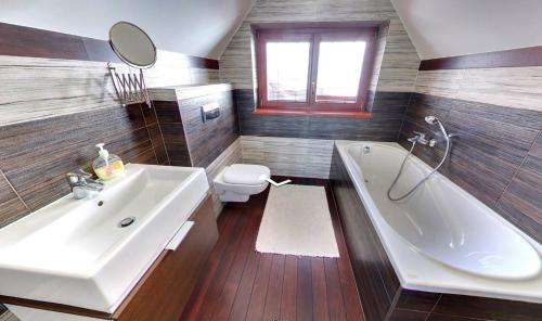uma casa de banho com uma banheira, um lavatório e um WC. em Villa Patriot - Penzión em Vysné Ruzbachy
