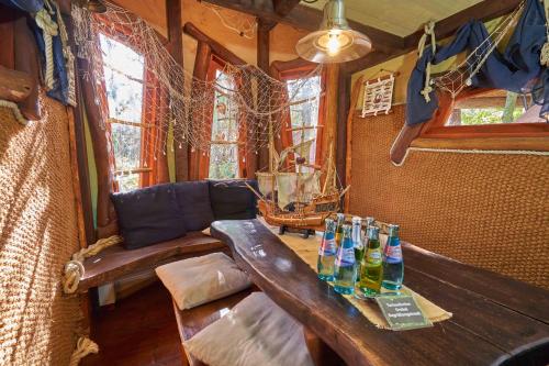 una sala de estar con una mesa de madera con botellas. en Baumhaushotel - Die geheime Welt von Turisede - Kulturinsel Einsiedel, en Zentendorf