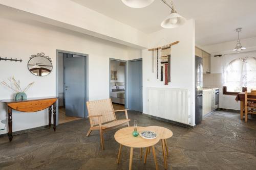 #FLH - Sun Kiss Cottage, Vourvourou في فوروفورو: غرفة معيشة مع طاولة وكراسي ومطبخ