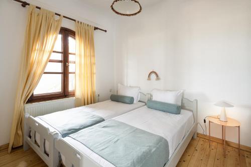 #FLH - Sun Kiss Cottage, Vourvourou في فوروفورو: غرفة نوم بسرير ابيض ونافذة