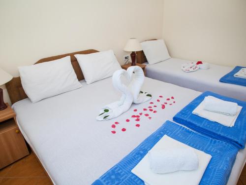 duas camas com toalhas e um cisne na cama em Daria Apartments em Kotor