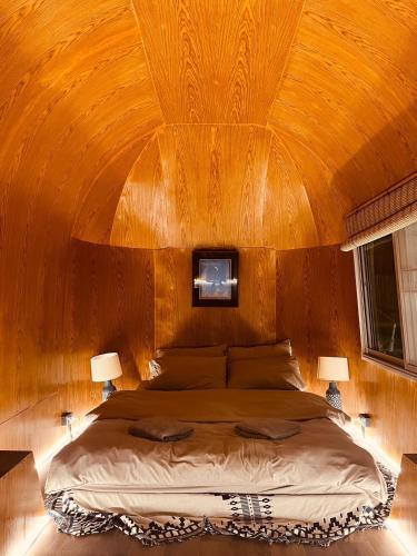 a bedroom with a large bed with a wooden ceiling at Greenspace Living in Ban Tha Phae