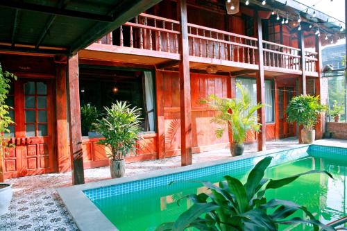 a house with a swimming pool in front of a building at Ninh Binh Green Homestay in Ða Gia