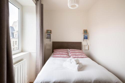 une chambre avec un lit avec deux serviettes dessus dans l'établissement Les Vigies by Cocoonr, à Saint-Malo