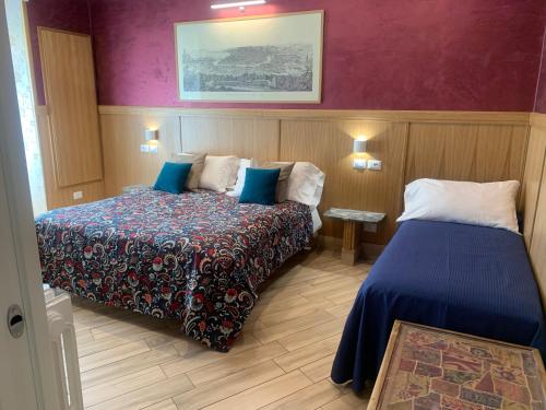 una camera d'albergo con due letti e pareti viola di B&B Acasadibarbara a Roma