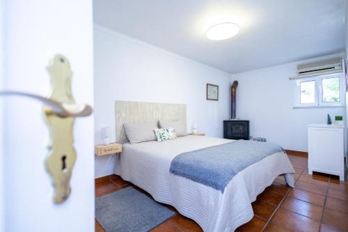 um quarto com uma cama branca e uma lareira em Cem Sentido - Alentejo Apartments em Portalegre