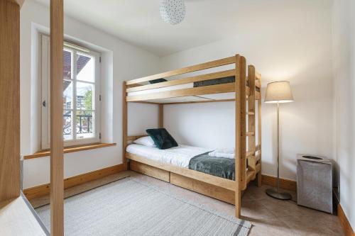 a bedroom with two bunk beds and a window at Conseil B - Chic 2BR City Center Apartment - Free Parking & Mountain View - By Cozee Rentals in Saint-Gervais-les-Bains