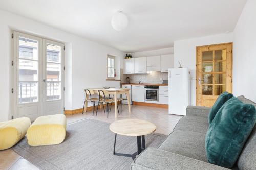 un salon avec un canapé et une cuisine dans l'établissement Conseil B - Chic 2BR City Center Apartment - Free Parking & Mountain View - By Cozee Rentals, à Saint-Gervais-les-Bains