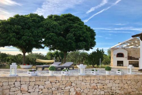 uma parede de pedra com um banco e uma árvore em Villa Catia em Alberobello