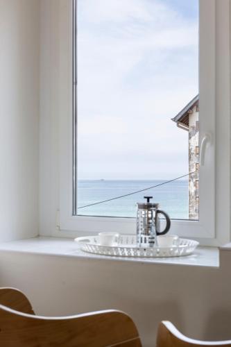 - une table avec une plaque de cuisson et une bouilloire devant une fenêtre dans l'établissement Les Vigies by Cocoonr, à Saint-Malo