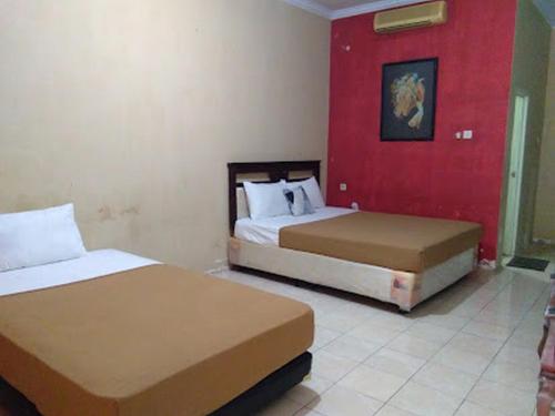 Hotel Nirwana Situbondo RedPartner tesisinde bir odada yatak veya yataklar