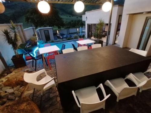 a table and chairs in a room with a pool at Sibebe View Villa in Mbabane