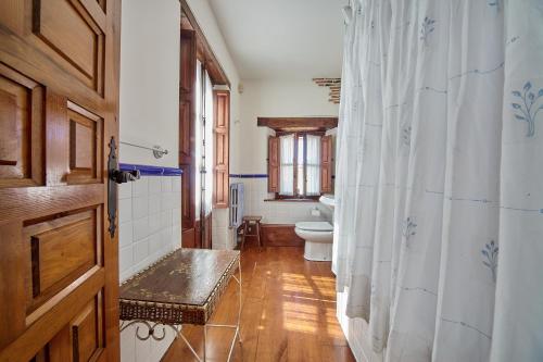 a bathroom with a toilet and a shower curtain at Casona los Cautivos in Oreña