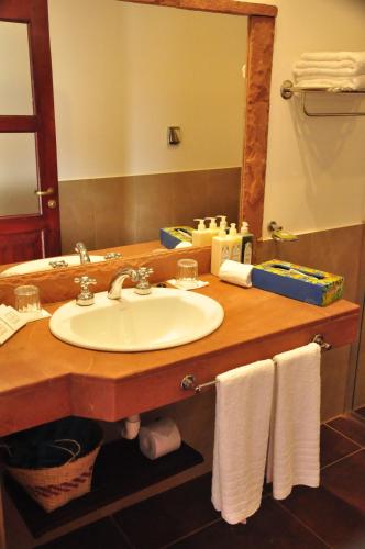 a bathroom with a sink and a mirror and towels at El Pueblito Iguazú in Puerto Iguazú