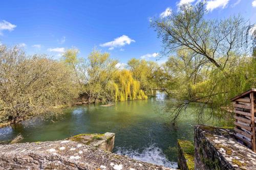 vista su un fiume con ponte e alberi di Finest Retreats - The Den a Stamford