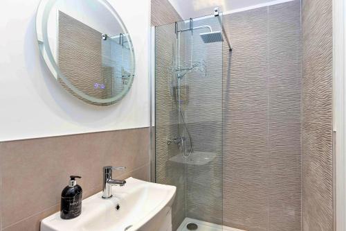 a bathroom with a shower and a sink and a mirror at Finest Retreats - The Sett in Stamford