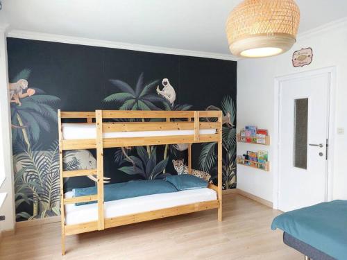 een slaapkamer met een stapelbed en een muurschildering van planten bij House 45 in Oostende