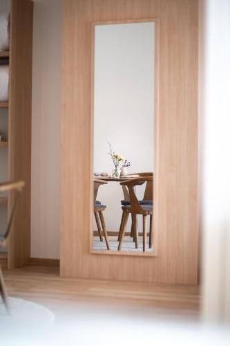 a reflection of a table and chairs in a mirror at Rosfjord Strandhotel in Lyngdal