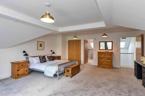 sypialnia z łóżkiem, drewnianymi meblami i telewizorem w obiekcie Finest Retreats - The Roost w mieście Stamford