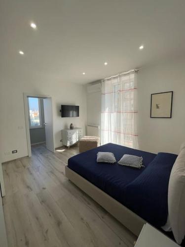 een slaapkamer met een blauw bed in een kamer bij Appartamento Dipinto di blu- Vista Mare! in Nettuno
