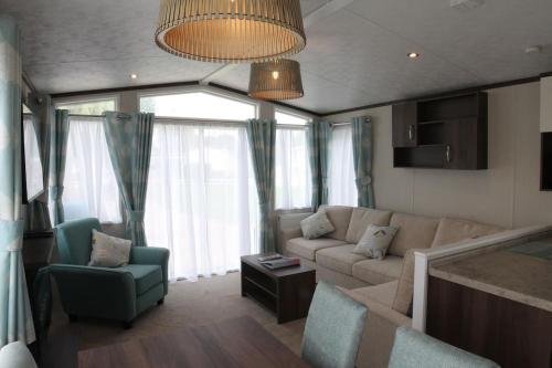 a living room with a couch and a chair at Countryside Holiday Park by the River nr Canterbury (Pet-Friendly) in Canterbury