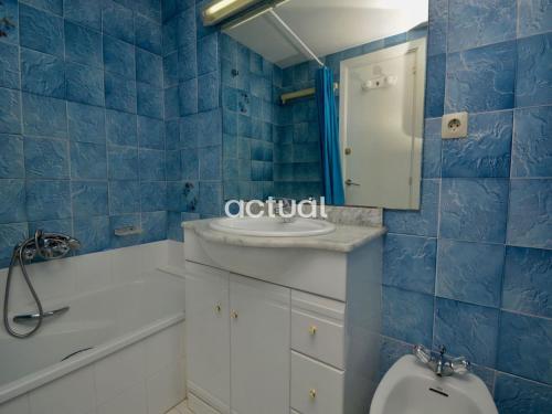 een blauw betegelde badkamer met een toilet en een wastafel bij TAMARIUS 1-4 in Platja  d'Aro