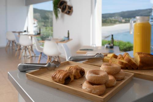 een snijplank met brood en gebak op een tafel bij Hotel Mar de Fisterra in Finisterre