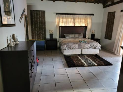 a bedroom with a bed with a window and a dresser at Alamo Guest Farm in Warmbaths