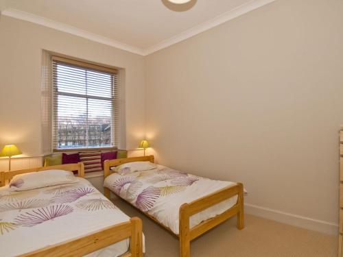 two twin beds in a room with a window at Seabreeze in North Berwick