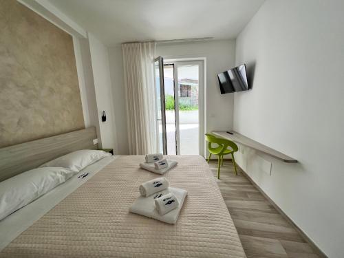 a bedroom with a bed with two towels on it at Vilu Suite Centro in Polignano a Mare