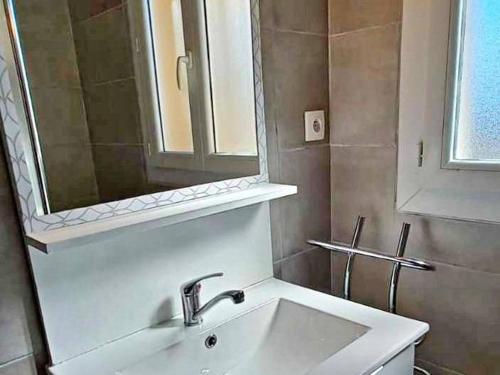 une salle de bain avec un lavabo et un miroir dans l'établissement Appartement à 2 pas de la plage avec terrasse et parking - FR-1-387-150, à Marseillan