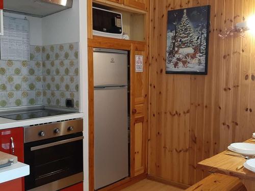une petite cuisine avec un réfrigérateur et un micro-ondes dans l'établissement Studio Montagne Montgenèvre - 5 pers, Balcon Sud, Proche Pistes et Navette - FR-1-330D-3, à Montgenèvre