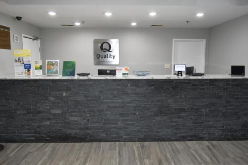a lobby with a brick counter with a sign on it at Quality Inn & Suites Brooks Louisville South in Brooks