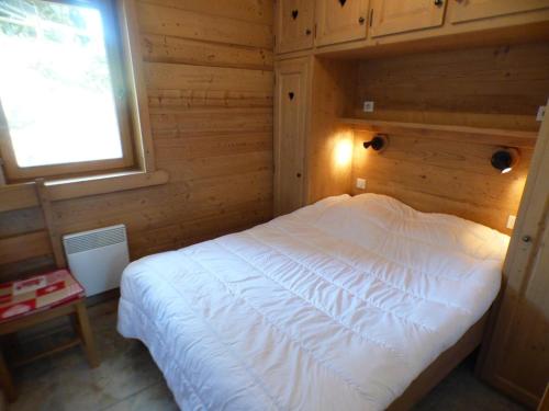 1 dormitorio con 1 cama blanca en una habitación de madera en Appartement Les Saisies, 5 pièces, 8 personnes - FR-1-594-70 en Hauteluce